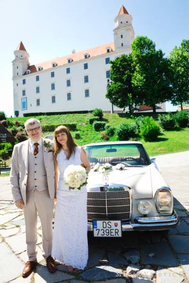 bride and groom - posing by vintage wedding mercedes - bratislava castle