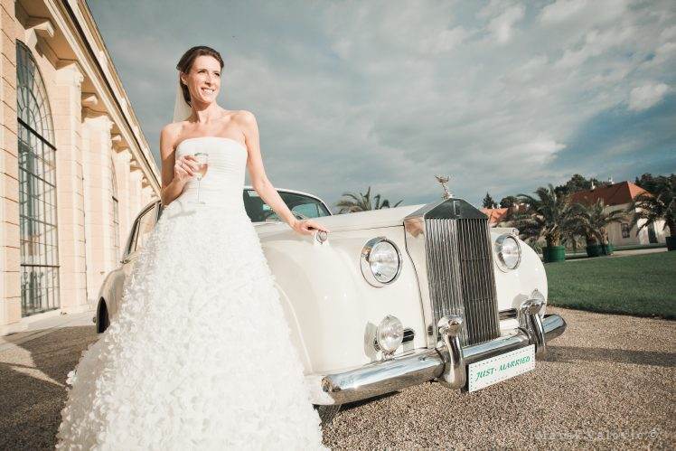 Bride naturally posing with Rolls Royce in Schonbrunn Vienna