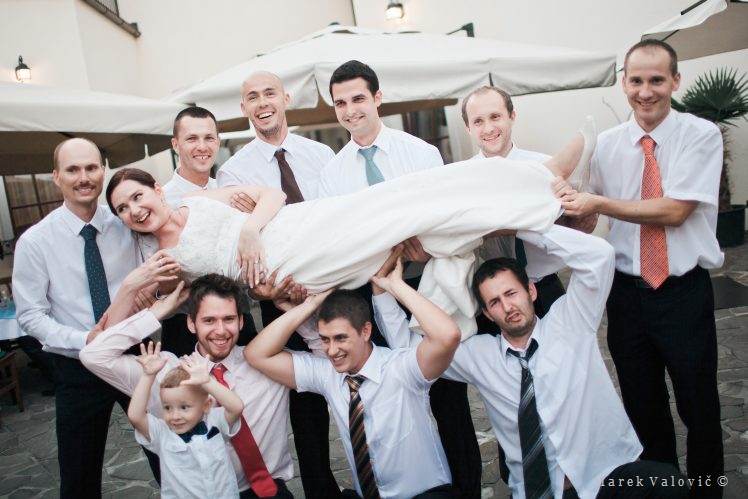 bride lifted on hands - group photo