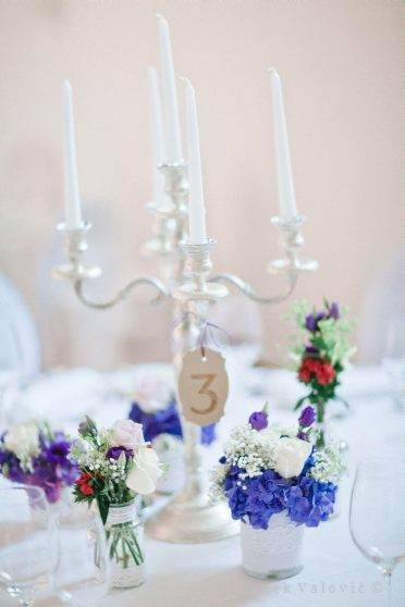 candle and blue and purple wedding decoration on table